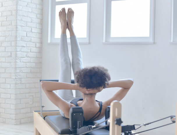 pilates Kでマシンピラティスをしている女性